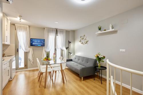ein Wohnzimmer mit einem Sofa und einem Tisch in der Unterkunft Apart-hotel Happy Life in Alicante