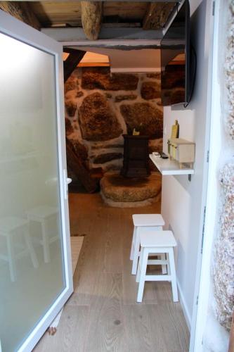 a room with a stone fireplace and a table and stool at Comfortable Apartment with Pool in Marco de Canaveses - 50 m² in Marco de Canavezes