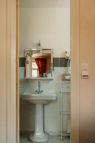 a bathroom with a sink and a mirror at Hôtel Le Cro-Magnon in Les Eyzies-de-Tayac