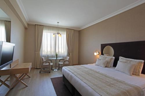 a hotel room with a large bed and a table at WOW Airport Hotel in Istanbul