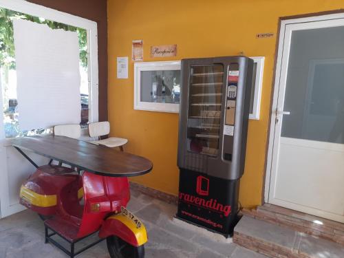 un cyclomoteur garé à côté d’une machine à soda dans l'établissement Room in Lodge - Las Quintas de los Mangas Verdes, à Quintana Redonda