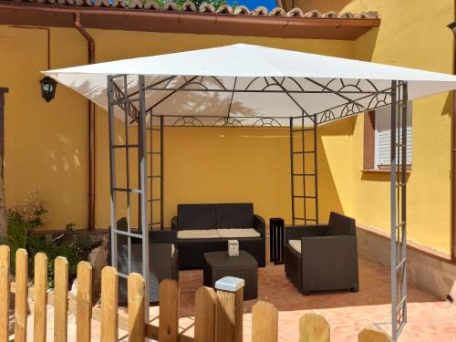 einen weißen Pavillon mit einem Tisch und Stühlen darunter in der Unterkunft Room in Lodge - Las Quintas de los Mangas Verdes in Quintana Redonda