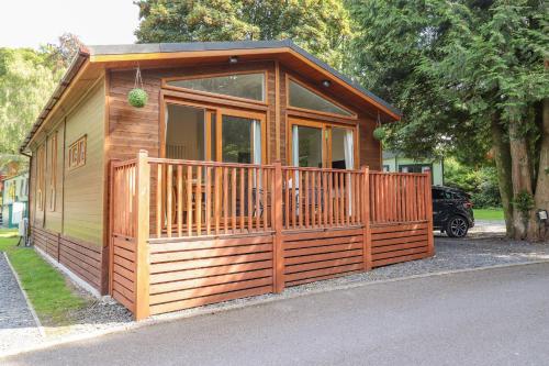 a small wooden cabin with a large window at Garuda in Windermere