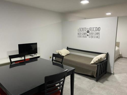 Departamento Oroño في روزاريو: غرفة نوم بسرير وطاولة وتلفزيون