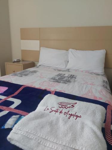 a bed with a comforter on top of it at Hotel La Suite de Angelique Huacho in Huacho