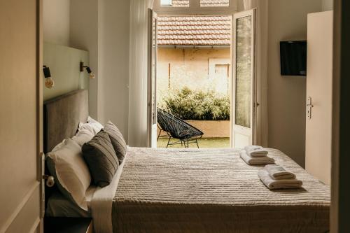1 dormitorio con 1 cama con toallas en Hôtel Le Cro-Magnon en Les Eyzies-de-Tayac