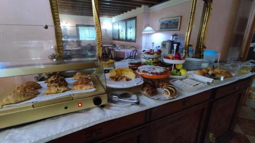 Hotel Antico Moro في Zelarino: بوفيه مع مجموعة متنوعة من المعجنات والأطعمة الأخرى على المنضدة