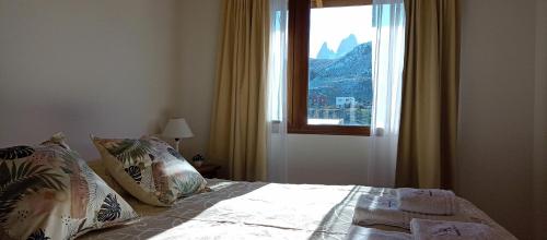 1 dormitorio con 1 cama y vistas a la montaña en Aparts Complejo Ricanor en El Chaltén