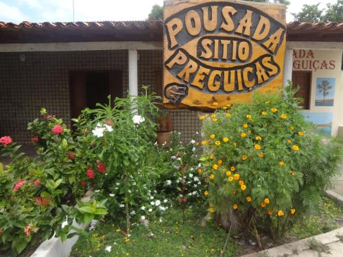 um sinal para um jardim de flores em frente a uma loja em Pousada Sitio Preguicas em Barreirinhas