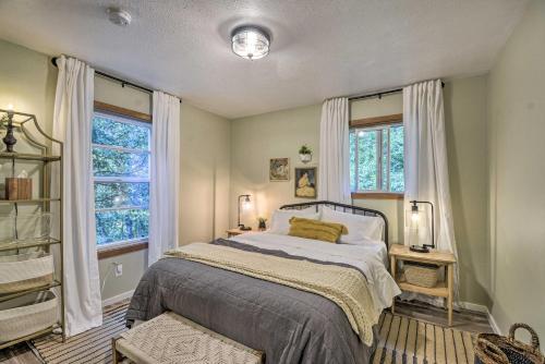 a bedroom with a bed and two windows at 100-Year-Old Farmhouse with Hot Tub on 5 Acres! in Lakebay