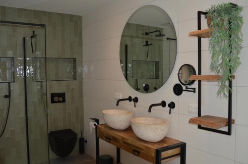 uma casa de banho com 2 lavatórios e um chuveiro em Olive Beach, luxury beachhouse 150 m from the beach em Noordwijk aan Zee