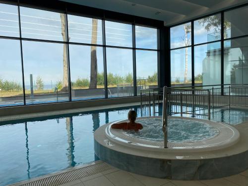 a person in a hot tub in a building with water at Relax Planet in Rewal