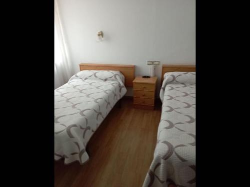 2 łóżka pojedyncze w pokoju z drewnianą podłogą w obiekcie Room in Lodge - Double and single room - Pension Oria 4 w mieście Luarca