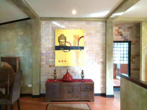 a room with a wooden cabinet and a painting on the wall at Sunshine Residence in Baan Tai