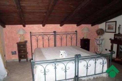 a bedroom with a bed with a dog sitting on it at Baglio Zio Ciccio in Altavilla Milicia