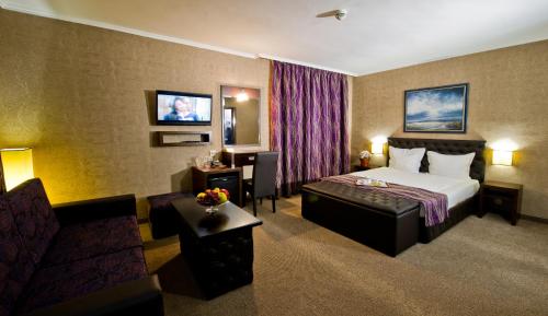 a hotel room with a bed and a couch at Spa Hotel Spartak in Sandanski