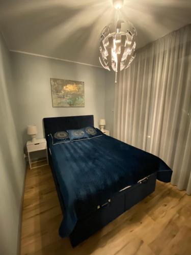 a bedroom with a blue bed with a chandelier at Relax Planet in Rewal