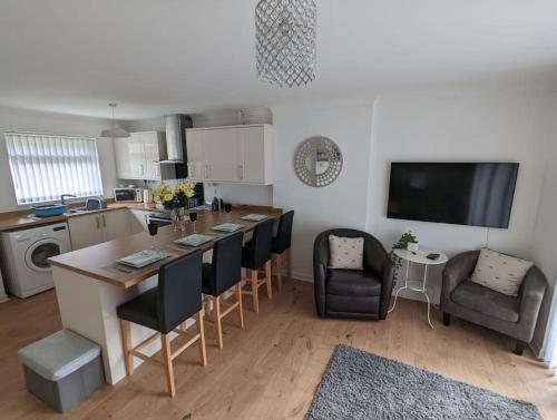 a kitchen with a table and chairs and a kitchen with a tv at THE KILSYTH,detached bungalow Warrington in Warrington