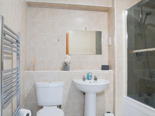 a bathroom with a toilet and a sink and a shower at Aurora in Lossiemouth