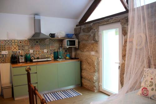 a kitchen with a green cabinet and a window at Charming Studio in Marco de Canaveses - 25m² with Pool in Marco de Canavezes