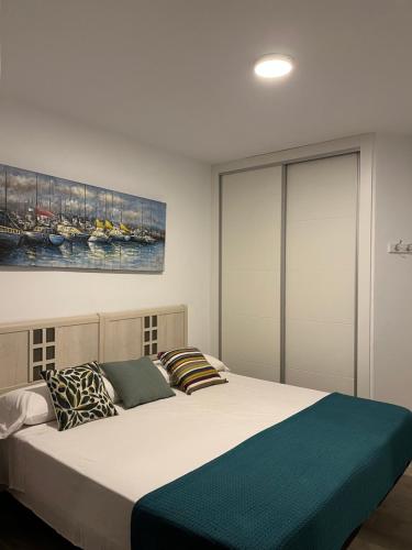 una camera con un grande letto e un dipinto sul muro di Anna’s apartment a Benidorm