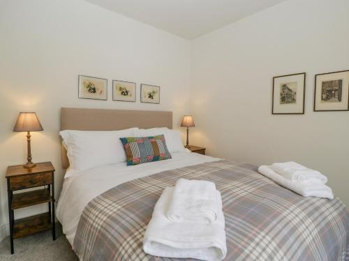 a bedroom with a bed with towels on it at Primrose Cottage in Cheltenham