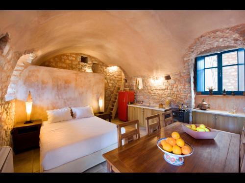 a bedroom with a bed and a table with a bowl of fruit at Arapakis Historic Castle in Pirgos Dhirou