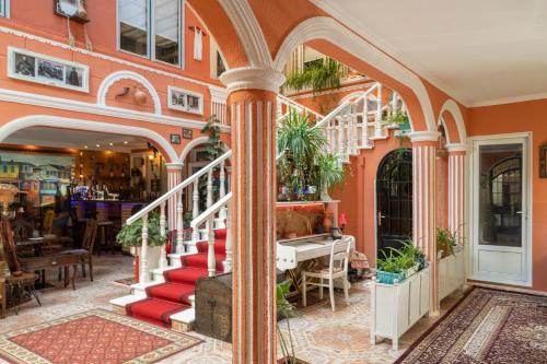 提比里斯的住宿－Elia Boutique Hostel & Apart-Hotel，拥有红色楼梯和植物的建筑入口