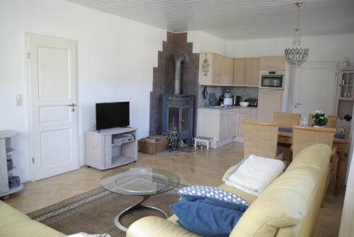 a living room with a couch and a glass table at Landhaus Sorgenfrey in Am Donnerberg