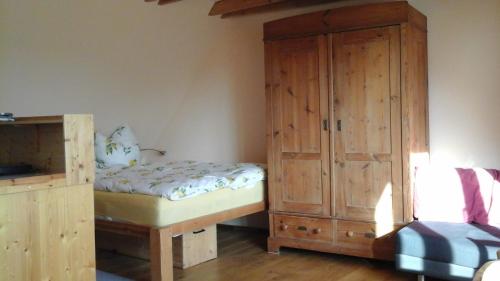 a bedroom with a bed and a wooden cabinet at Südblick in Röttenbach