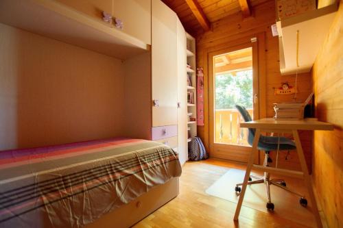a bedroom with a bed and a desk and a window at Chalet di San Martino in San Martino in Colle