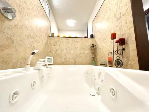 a bathroom with a white tub with a sink at Chalet di San Martino in San Martino in Colle