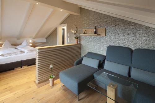 a living room with a bed and a couch and a chair at Boutique Hotel Gams in Oberstdorf