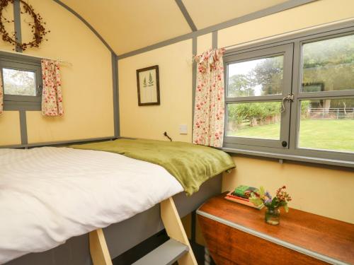 a bedroom with two bunk beds and a window at Brown Hare Shepherds Hut in Brecon
