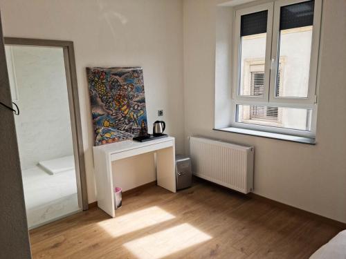 a white room with a table and a window at La Factory in Porrentruy