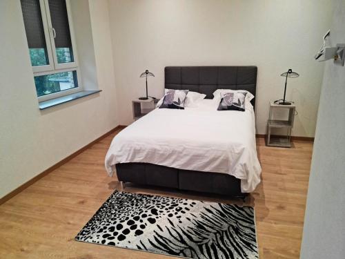 a bedroom with a bed and a black and white rug at La Factory in Porrentruy