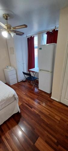 um quarto com uma cama, uma mesa e um frigorífico em Silver rooms em Edmonton