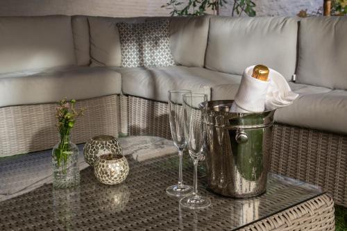 a living room with a couch and a table with wine glasses at The Hamptons Boutique Hotel in Ghent
