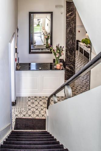 a staircase in a house with a mirror and a hallway at The Hamptons Boutique Hotel in Ghent