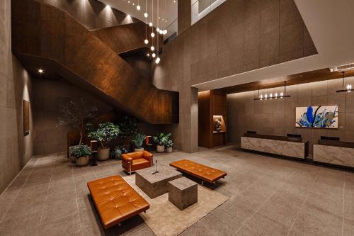 a lobby with a table and benches in a building at Citadines Connect Hari Busan in Busan