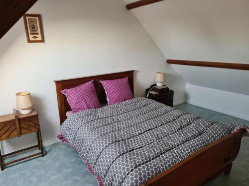 1 dormitorio con 1 cama grande con almohadas rosas en Maison chaleureuse près de Rocamadour, en Alvignac