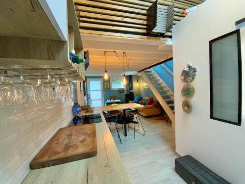 - une cuisine et une salle à manger avec une table et des escaliers dans l'établissement LOFT BULOT MAYO’S à 200 Mètres de la plage ., à Wimereux