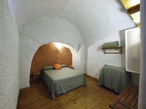 a bedroom with a bed in a room with a ceiling at Casas Cueva y Cortijo La Tala en Guadix in Guadix