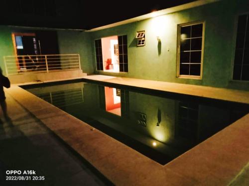 a swimming pool in a house at night at Daisy Aircon Room 1 with Private Toilet and Bath in Bacolod