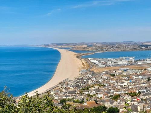 a view of a beach with houses and the ocean at Sea View Cottage in Dorset, Portland in Portland