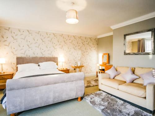 a bedroom with a bed and a couch at Blashford Manor Farm House in Ellingham