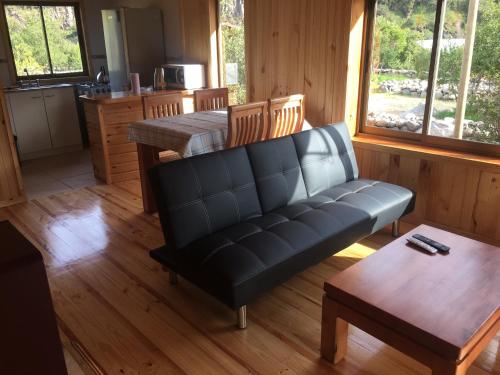 a living room with a couch and a table at Los Quenes River Lodge in Los Queñes