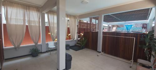 a room with a balcony with curtains and plants at Waterland Suites in Paramaribo