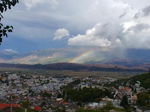a rainbow in the sky over a city at Panoramic Vlachos in Gjirokastër