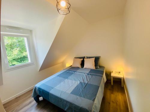 - une chambre avec un lit bleu et une fenêtre dans l'établissement Maison ZETNA ,3 chambres et jardin,Penecam ,Le Palais, au Palais